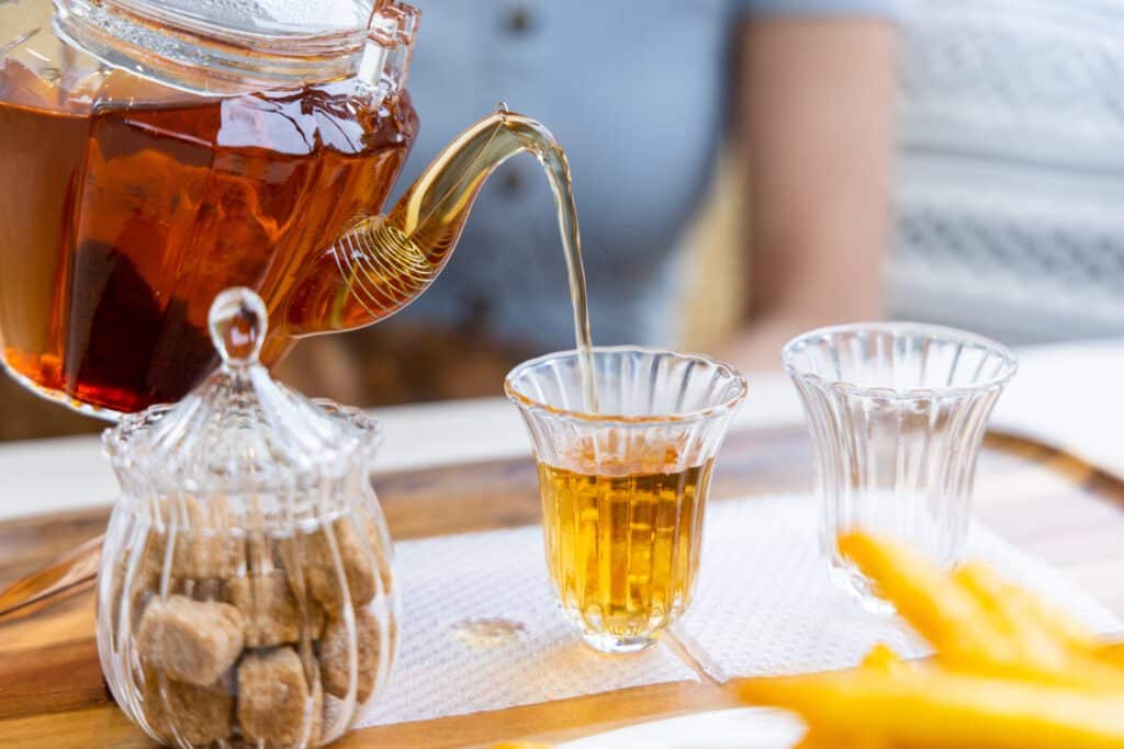 Tea poured from a teapot into a white cup