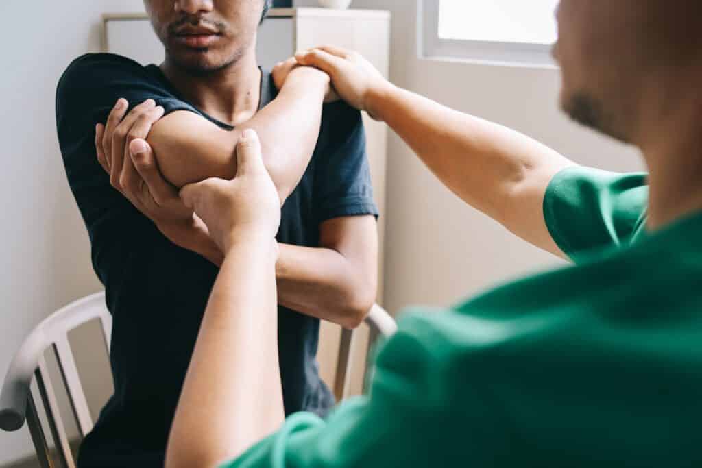 Clinician treating an elbow injury during a clinic visit