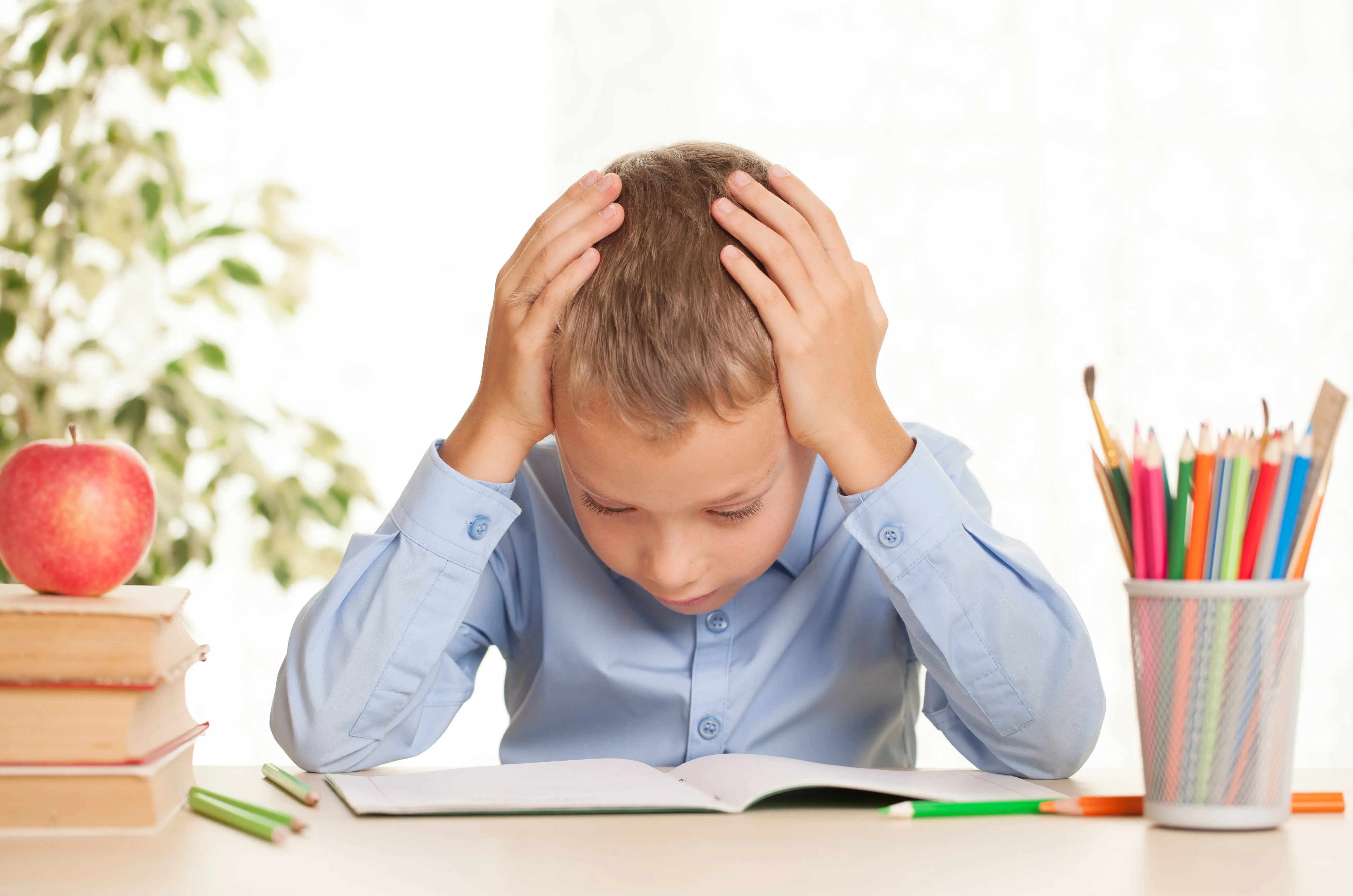 a boy holding his head with cognitive delay