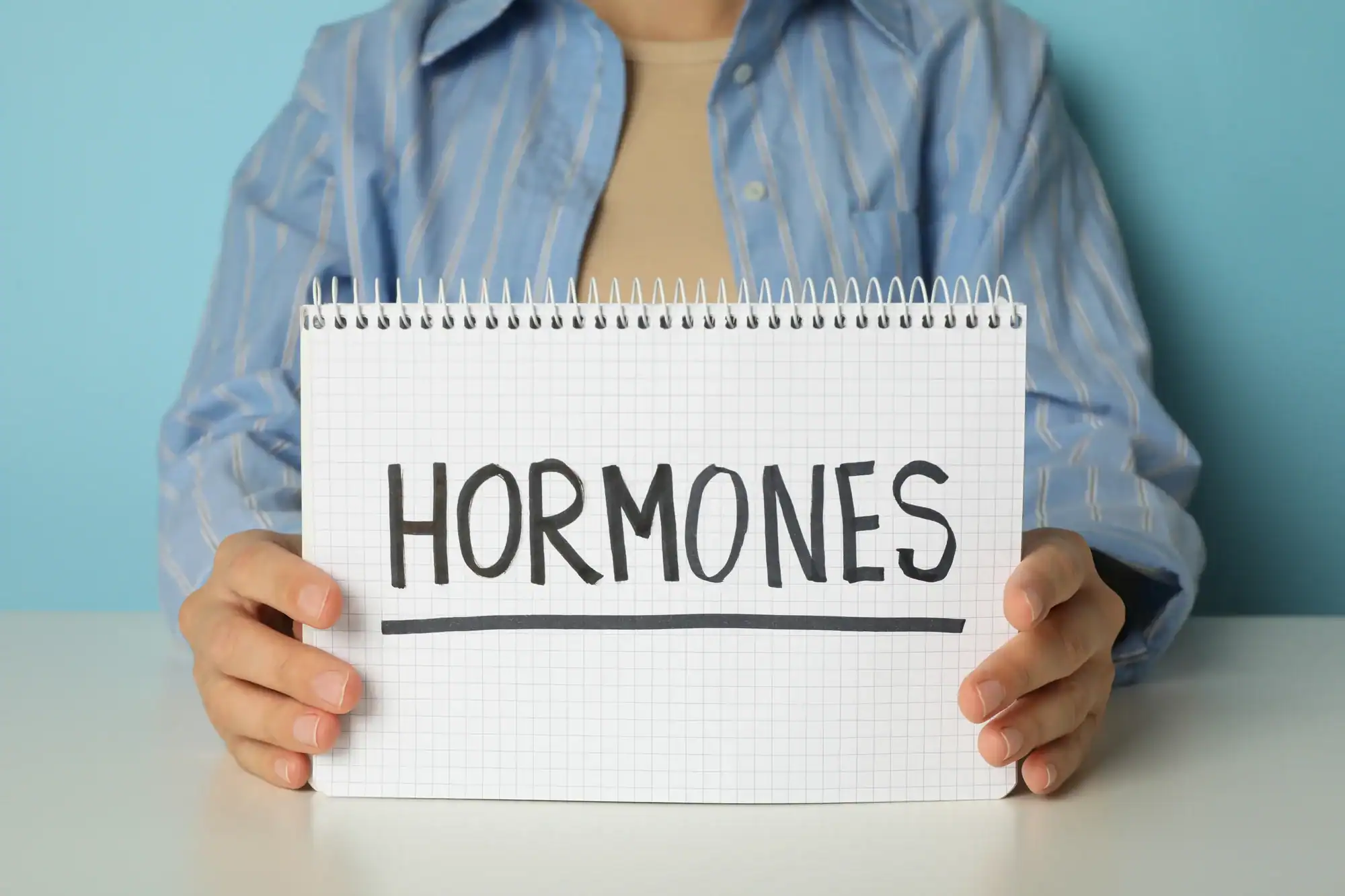 Hormone Imbalance a person holding a notebook with a sign for Who to See for Hormone Imbalance